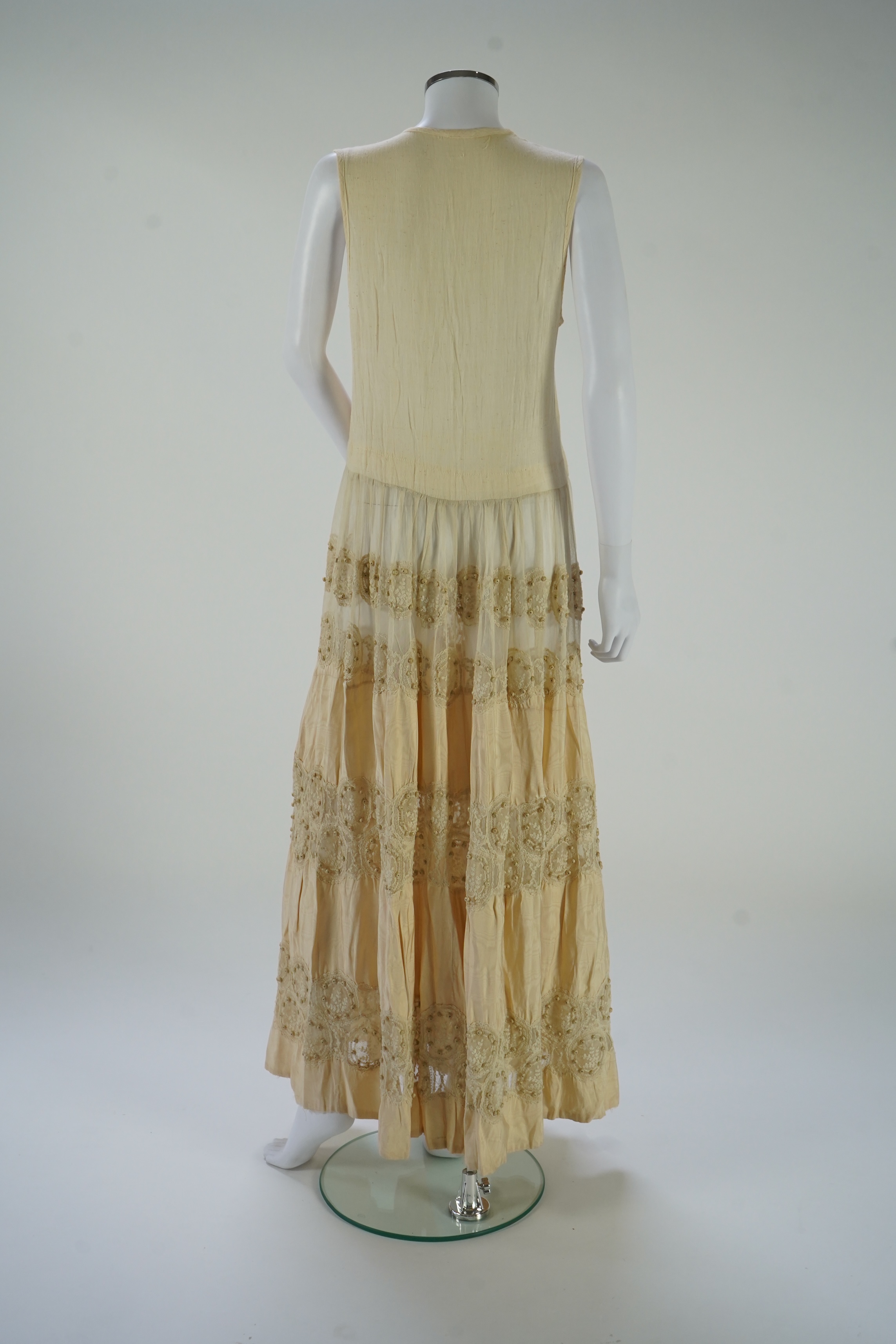 A suitcase containing a cream silk lace skirt to a dress, an Edwardian silk petticoat and various collars, possibly for theatrical use, silk petticoat 96 cm long. Condition - fair